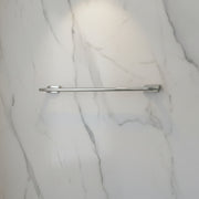 Chrome towel bar mounted on a white tiled wall