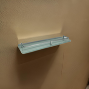 Modern floating glass shelf mounted on a white wall with decorative plants